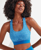 A blue sport bra with a seamless design and a contrasting blue band, featuring a logo.