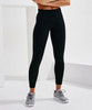 Performance leggings in black with pockets, paired with grey athletic shoes, displayed against a minimalist white background.