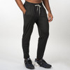 A pair of black soft jersey joggers with an elastic waistband and side pockets, worn with athletic shoes.