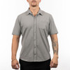 A short sleeve shirt in grey, featuring a button-up front and a chest pocket, displayed on a model.