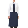 A navy apron worn over a white shirt and tie, featuring a front pocket and a simple design.