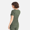 A woman models a dark green, fitted Y-neck top with a logo on the back, featuring a tuckable design.
