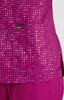 A vibrant fuchsia top featuring a pocket, adorned with a pattern of reflective dots, with a logo present.