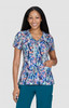 A floral print scrub top in vibrant colours, featuring a V-neck and short sleeves, with a pocket on the side.