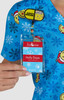 A blue printed top featuring various cartoon characters and snowflakes, with a staff name badge attached.