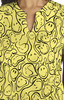 A vibrant yellow top featuring a playful print of smiling faces and abstract shapes, with a pocket detail.