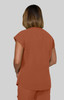 A back view of a woman wearing an orange, short-sleeved top made from a lightweight fabric.