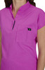 A pink women's top featuring a collar, short sleeves, and a breast pocket. The top includes a logo on the pocket.