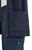 A navy Kori Sweater featuring ribbed textures and a large front pocket, with a branding logo.