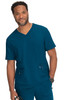 A man wearing a teal V-neck medical scrub top with two front pockets and a logo on the chest.