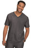 A man wearing a grey scrub top with a V-neck design and two front pockets, smiling confidently.