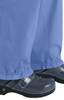Light blue Lindsey Pants paired with shiny black footwear, featuring a logo. The fabric has a relaxed fit.