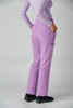 A pair of lilac boot cut pants with pockets, worn by a model from the back.