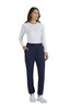 A woman is wearing limited edition navy Harper pants paired with a white long-sleeve top and white shoes.