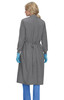 A clinical cover gown in grey, featuring a back tie and long sleeves, worn by a person with blue gloves.