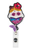 A pink and white shaker badge featuring a cat mermaid design with a flower and glitter elements, and a logo.