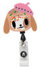 A colourful tokidoki Shaker Badge featuring a dog character with sprinkles and a pink hat, attached to a clear clip.