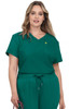 A short-sleeved, v-neck scrub top in teal with a chest pocket and a small logo, styled on a model.