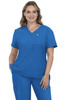 A woman wearing a blue medical scrub top with a pocket, featuring a logo on the chest. She has wavy hair and is smiling.