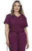 A woman wearing a short-sleeved, burgundy medical scrub top with a pocket and matching jogger-style pants.