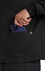 A black jacket with a pocket, featuring a person placing a smartphone inside the pocket.