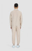 A beige men's jacket and matching pants are displayed from the back, featuring a simple design and a logo.