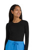 A woman wearing a long-sleeved black top with a speckled pattern, paired with blue trousers.