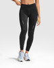 Black leggings with a fitted design, featuring reflective details, paired with light blue sneakers.
