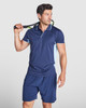 A navy blue polo shirt with light blue accents, worn by a man holding a tennis racquet.