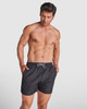 Black swimming shorts with an elastic waistband and drawstring, featuring a branding logo.