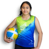 A girl holding a volleyball wears a custom sports singlet featuring green and blue colours, with a logo present.