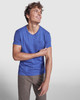 A blue T-shirt with short sleeves and a pocket, worn by a smiling man in casual attire.