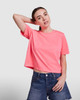 A cropped top in bright pink, featuring short sleeves and a loose fit, paired with denim shorts.