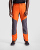 Hiking trousers in vibrant orange and grey, featuring a branded logo, designed for outdoor activities.