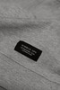 A grey sweatshirt featuring a label with branding details at the neckline.