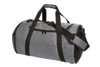 A grey duffel bag with black accents, featuring dual handles and a detachable shoulder strap. It has a logo.