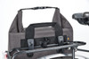 A grey cycle bike bag with a handle and fastening, attached to a bike rack. It has a sturdy design and a logo.