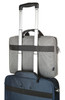 A grey laptop bag with black straps, stacked on top of a blue suitcase with telescopic handles.