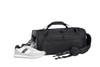 A black duffle bag with a shoulder strap, accompanied by a pair of white and grey sneakers. The bag features a logo.