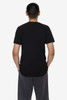A plain black short sleeve fine jersey crew tee displayed on a person from the back, hands in pockets.