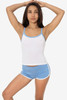A woman poses in a white baby rib spaghetti tank top with light blue trim, paired with matching shorts.