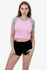 A short sleeve baby rib raglan tee in pink with grey sleeves, paired with black shorts; model is standing.