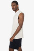 A sleeveless tee in off-white, featuring a simple design and a logo, paired with dark shorts.