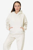 A model wearing a cream-coloured mineral wash fleece wide hoodie, featuring a hood and front pockets.
