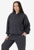 A woman wearing a dark grey Mineral Wash Fleece Wide Hoodie, featuring a hood and front pocket.