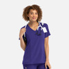 A women's mock wrap top in deep purple, featuring a V-neck and a stethoscope around the neck. The top has a logo.