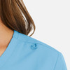 A close-up of a light blue women's mock wrap top, featuring a loop detail at the collar.