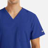 A blue men's V-neck top with four pockets and a logo, featuring a modern fit design.