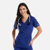 A woman wearing a blue double V-neck top with a stethoscope around her neck, featuring two pockets.