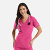 A woman wearing a pink double V-neck top with a stethoscope, featuring pockets and a logo on the sleeve.